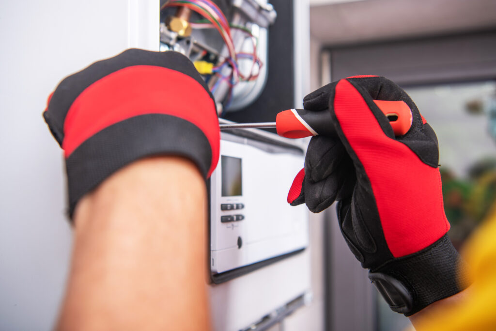 HVAC Technician Repairs Broken Gas Heater Device.