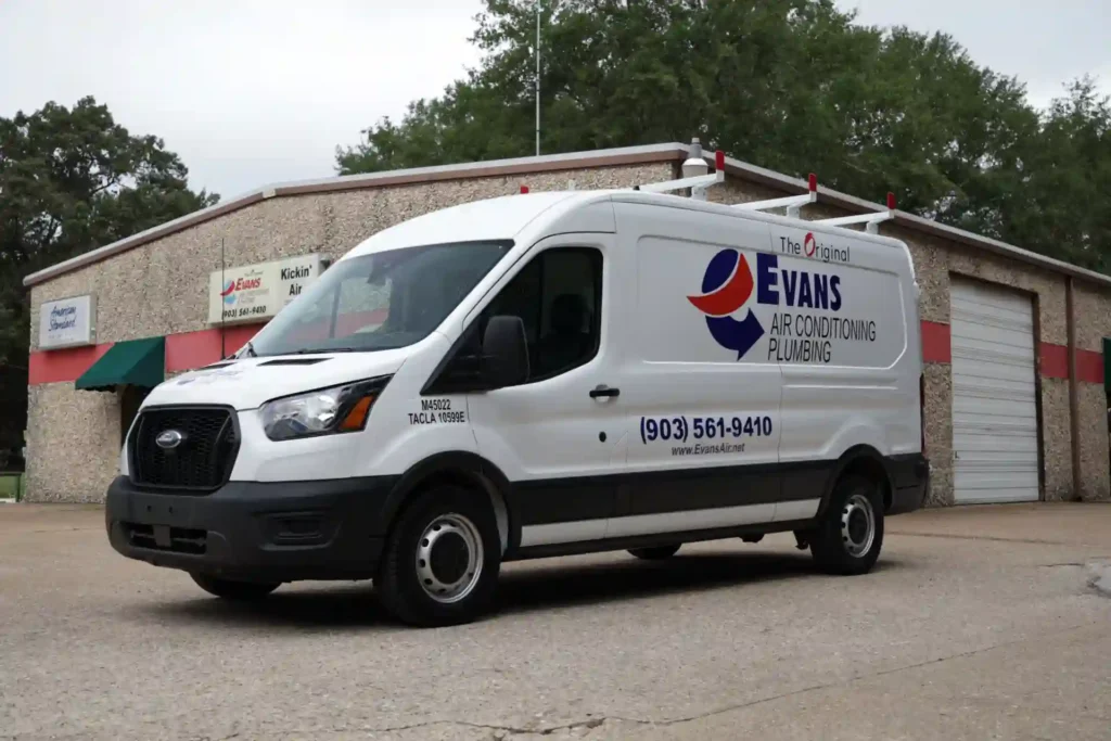 Evans Air service van parked outside company headquarters in Tyler, TX, providing HVAC, plumbing, and emergency electrical services including rewiring, generator installation, and home automation.