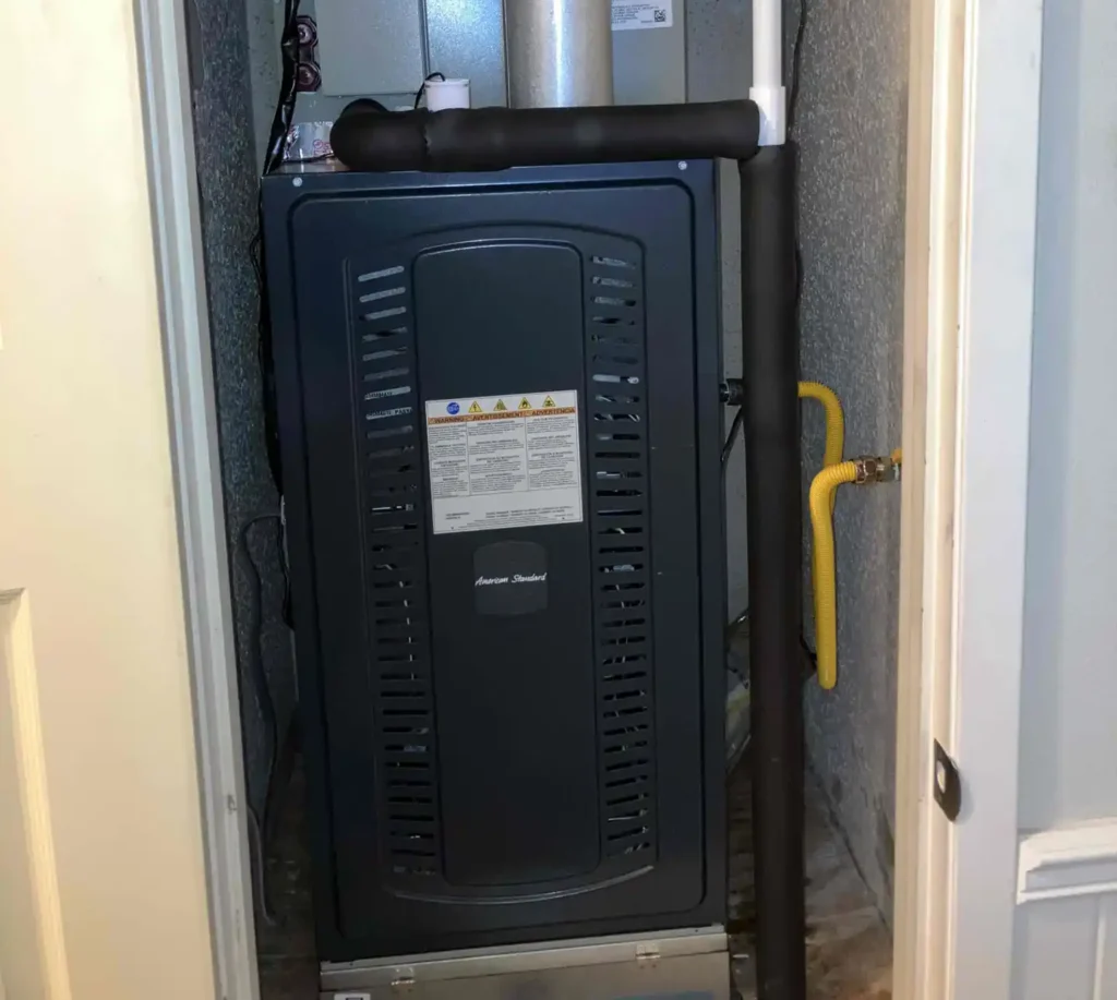 New furnace installation in utility closet with metal exhaust flue and yellow gas supply line