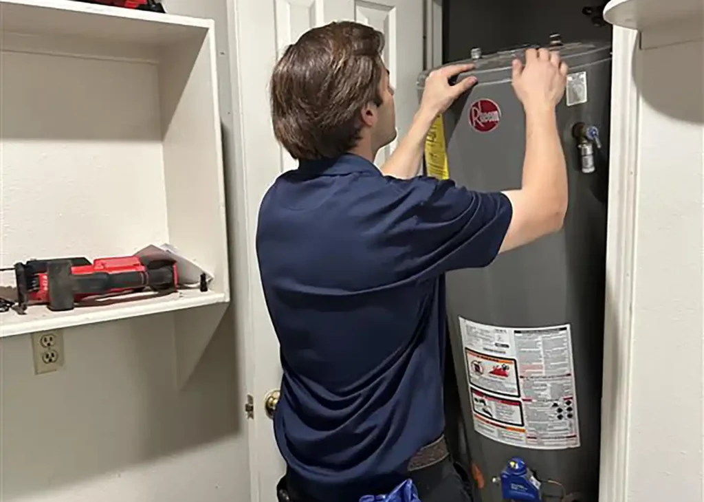 Evans Air plumber removing an old Rheem water heater during a water heater replacement
