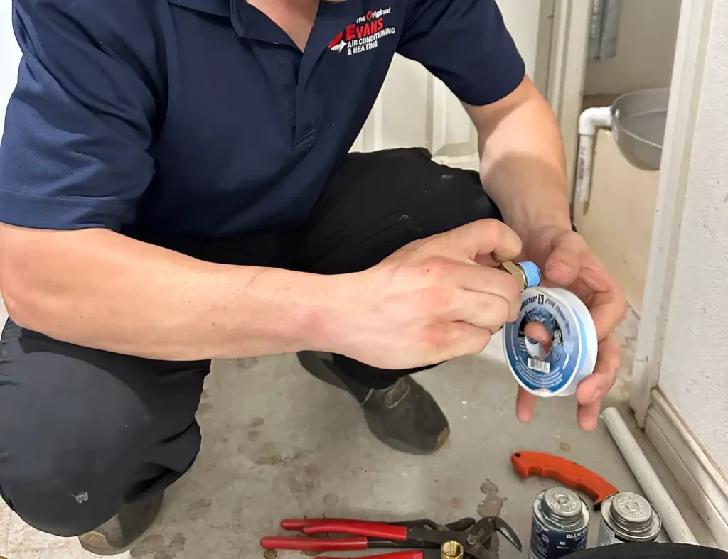 plumber working with sealing tape on plumbing job